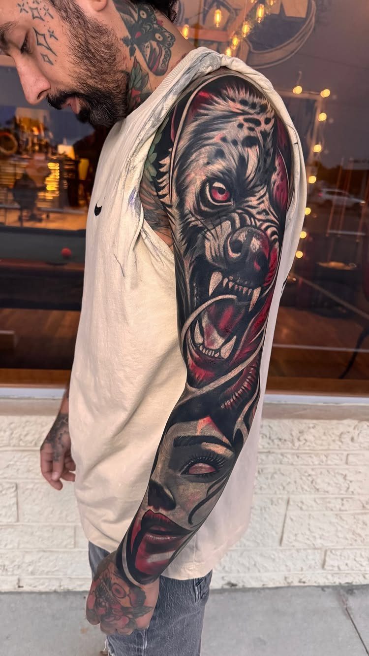 Full arm sleeve tattoo featuring a snarling beast and a woman's realistic portrait.