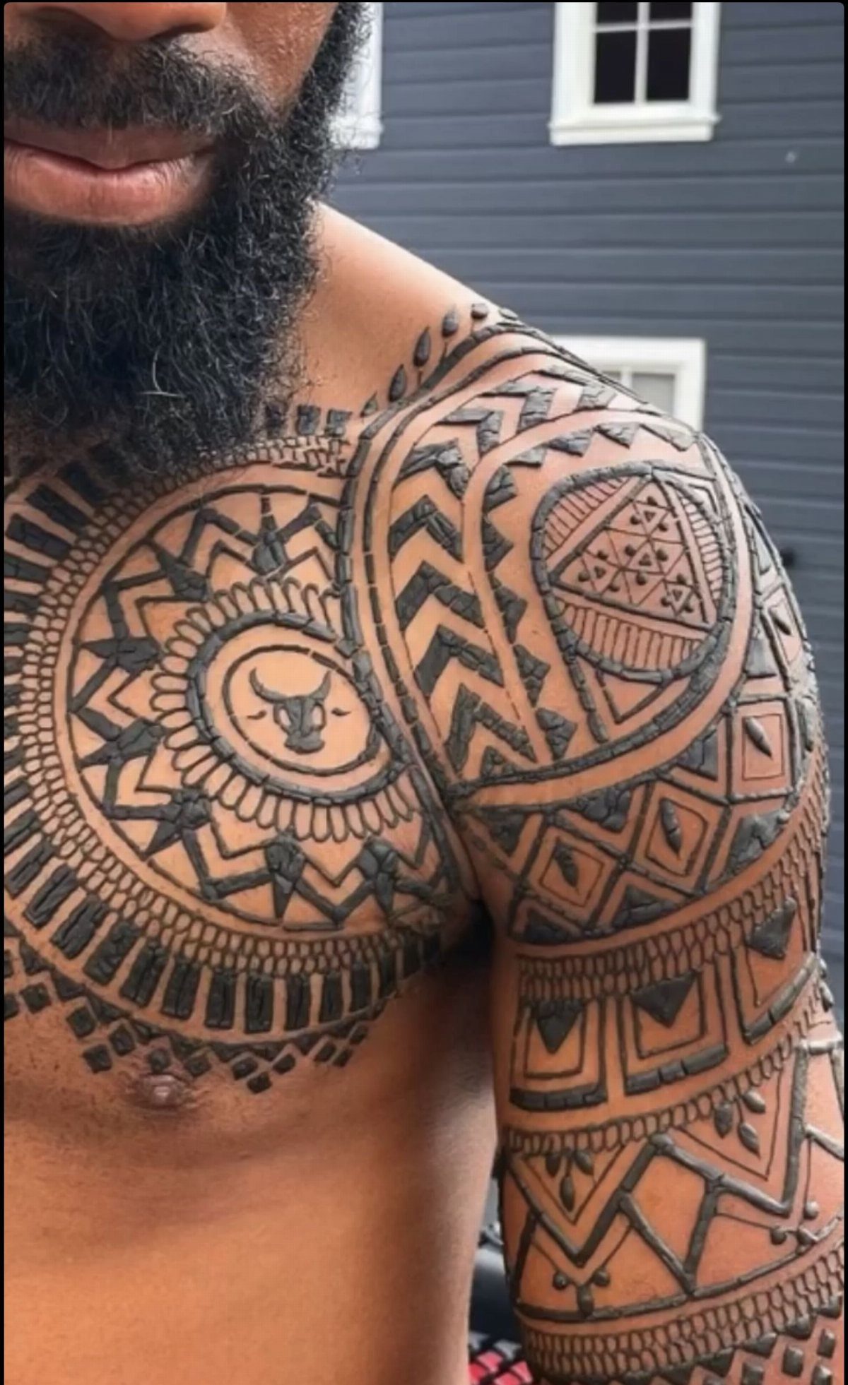 Man with concentric circular henna tattoo and bull motif on his chest