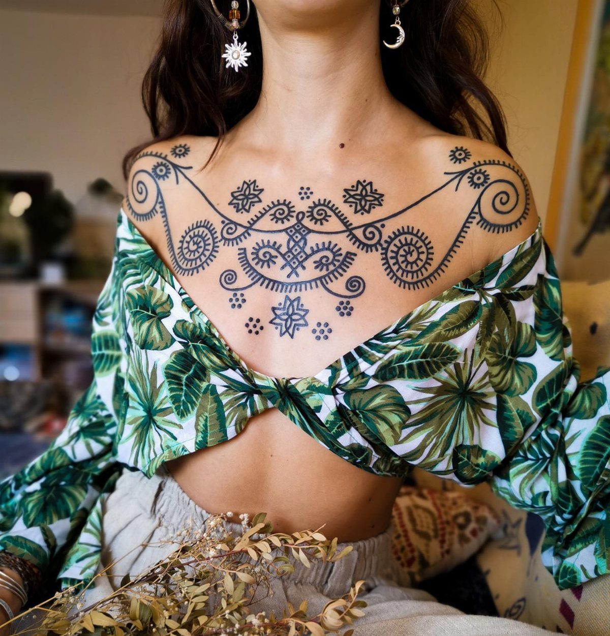 Mandala-style henna necklace tattoo on a person's chest and collarbone area
