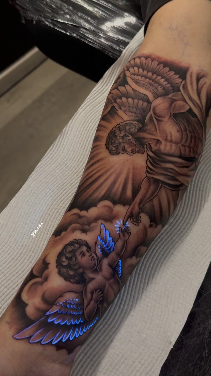 Black and grey tattoo of angels and cherubs surrounded by realistic fluffy clouds.