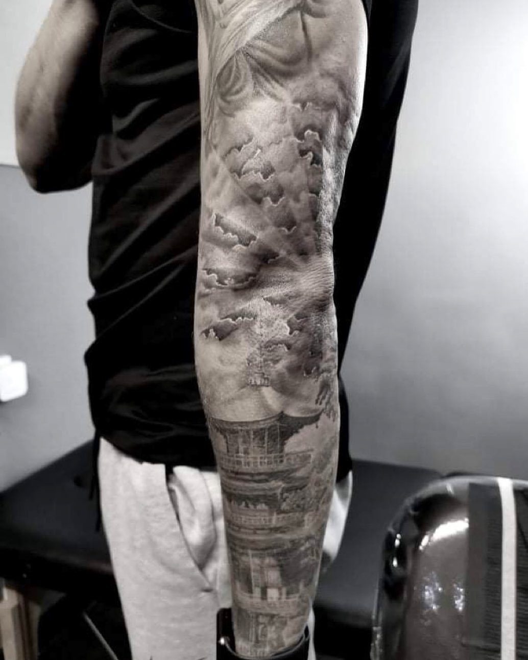 Japanese cloud filler tattoo on an arm featuring a traditional pagoda design