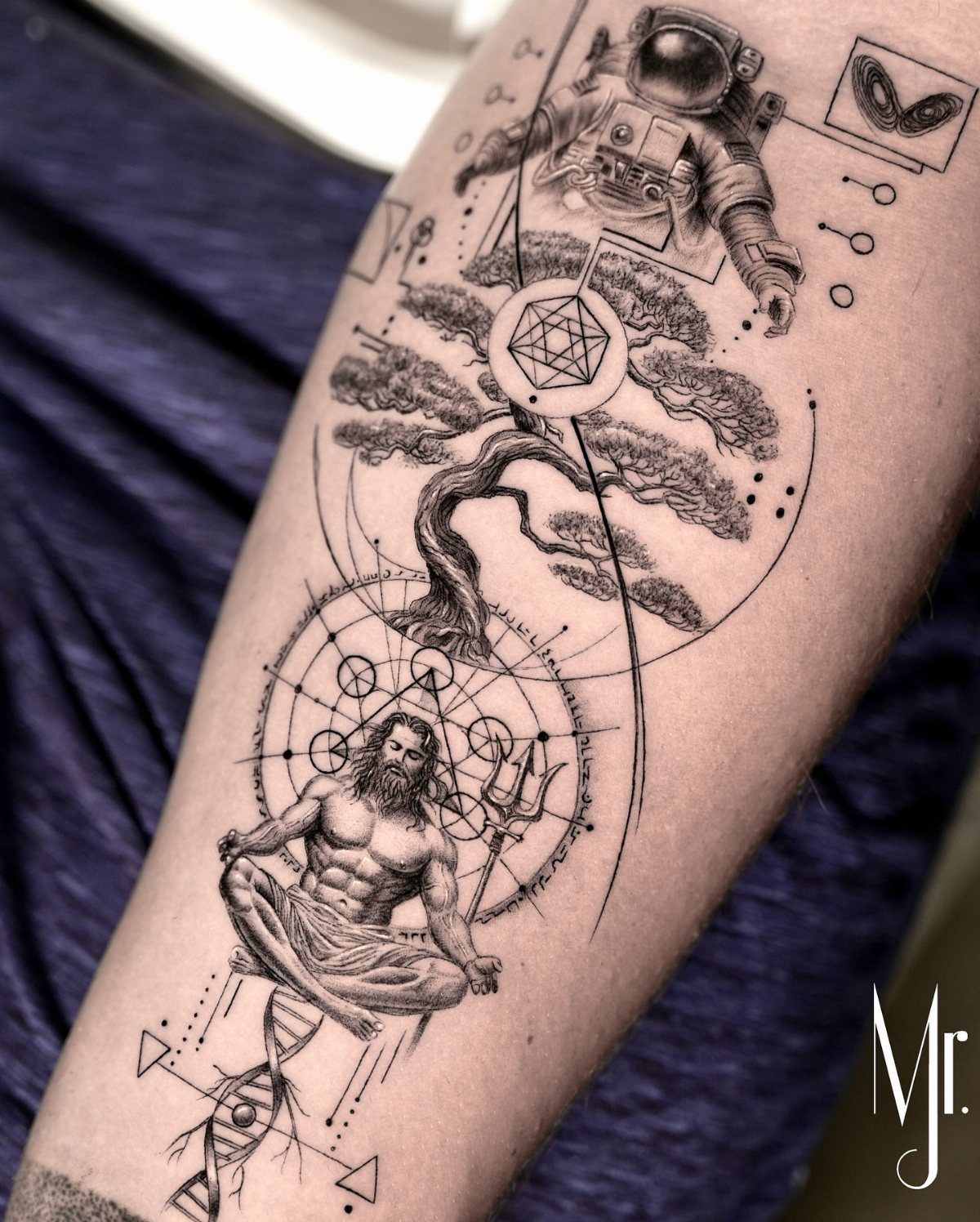 Intricate black ink tattoo featuring an astronaut, bonsai tree, and meditating figure on skin.