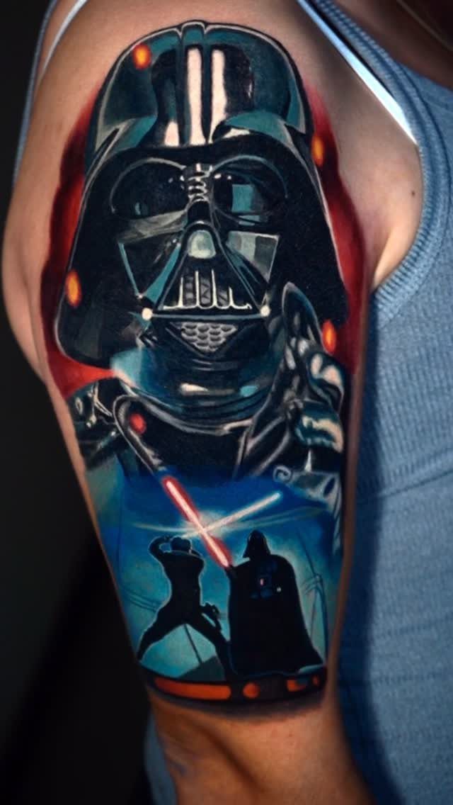 Darth Vader tattoo on an arm featuring a lightsaber duel in vibrant colors.
