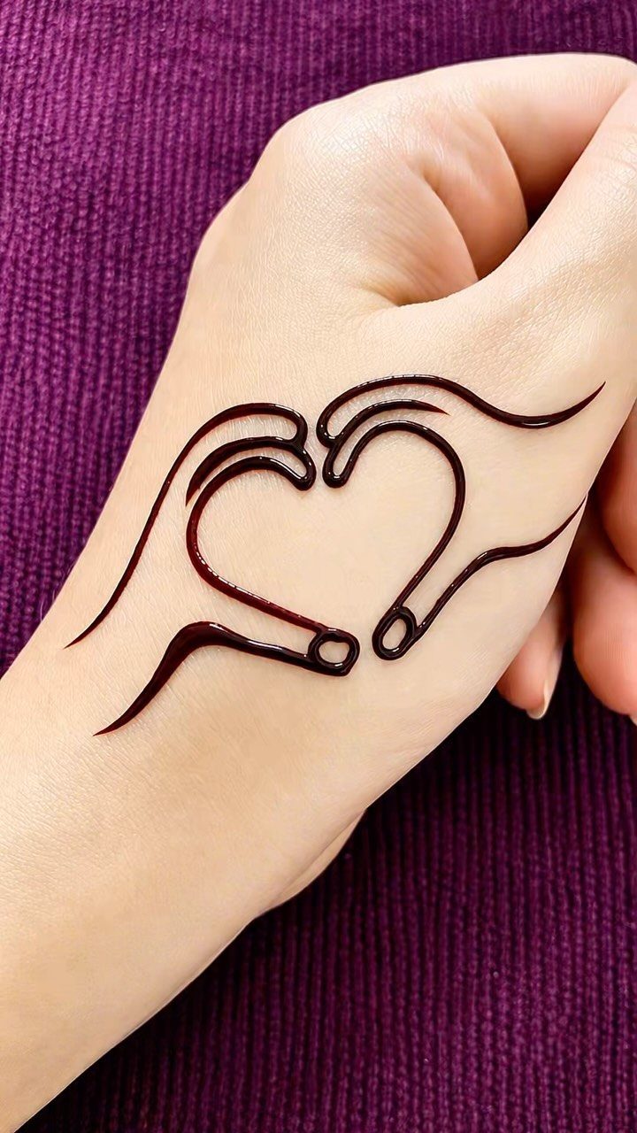 Henna tattoo on a hand depicting two hands forming a heart shape