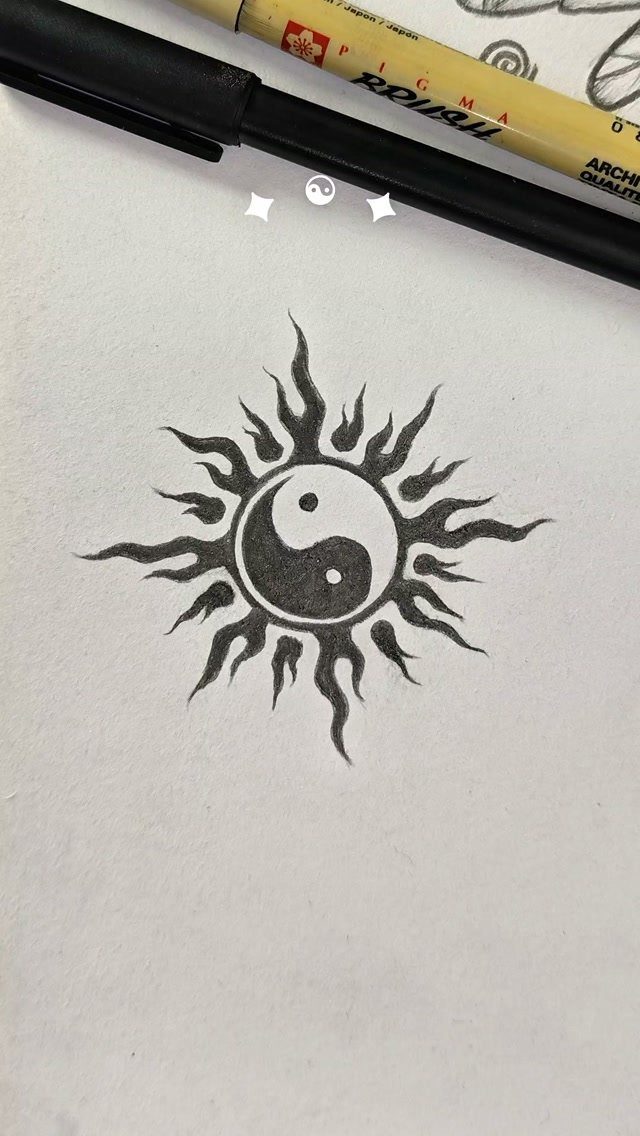 Yin yang symbol with sun rays drawn in black ink on white paper.