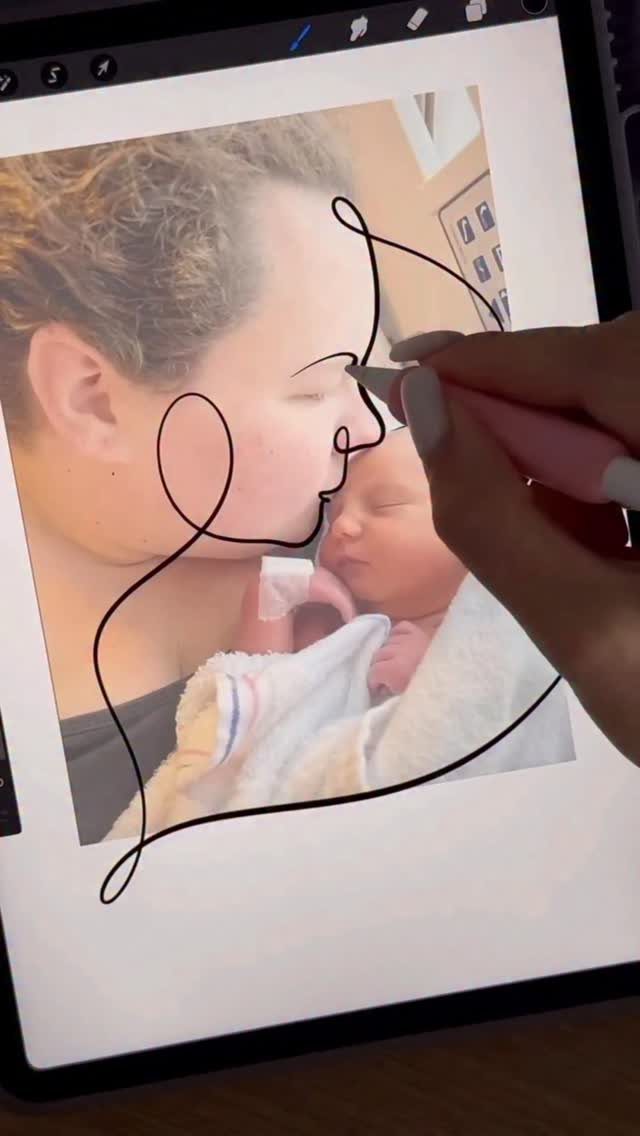 Hand drawing a minimalist line art tattoo design over a photo of a mother and baby.