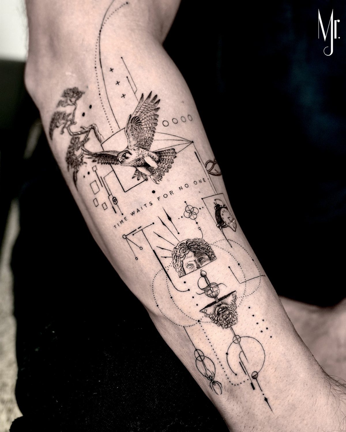 Forearm tattoo with a bird, face, and geometric line art in black ink.