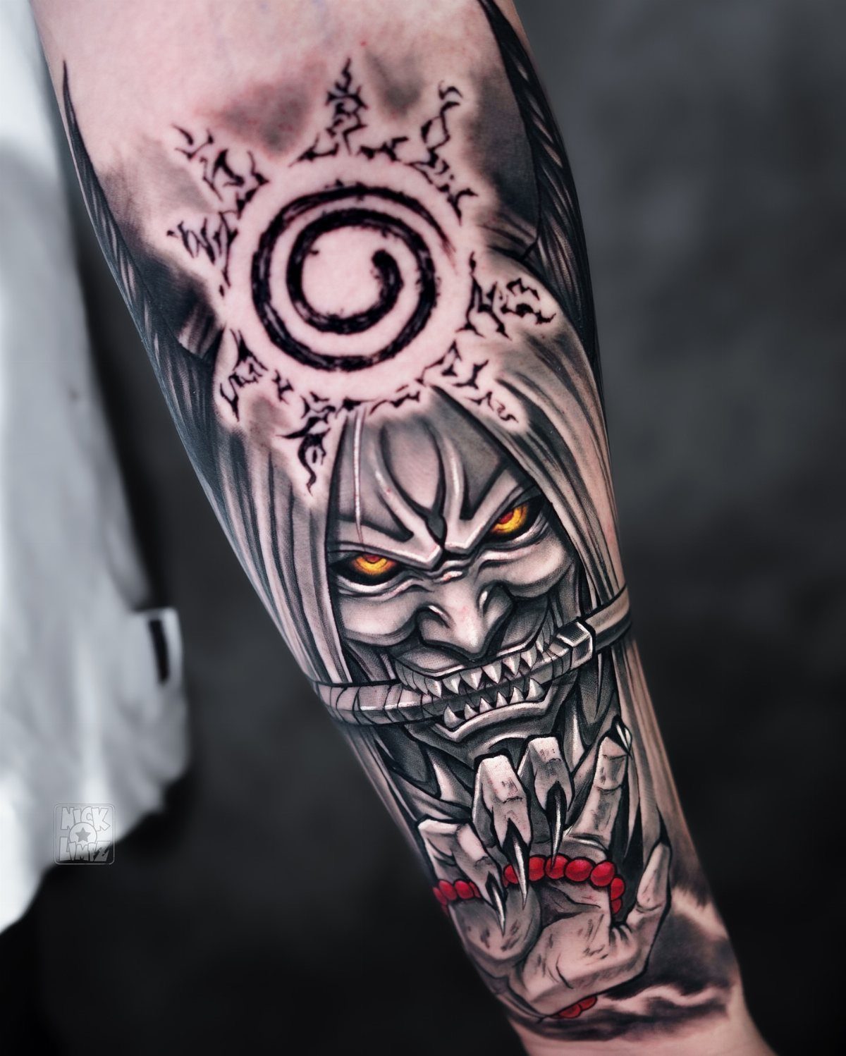 Anime character tattoo on an arm with glowing yellow eyes and spiral symbol.