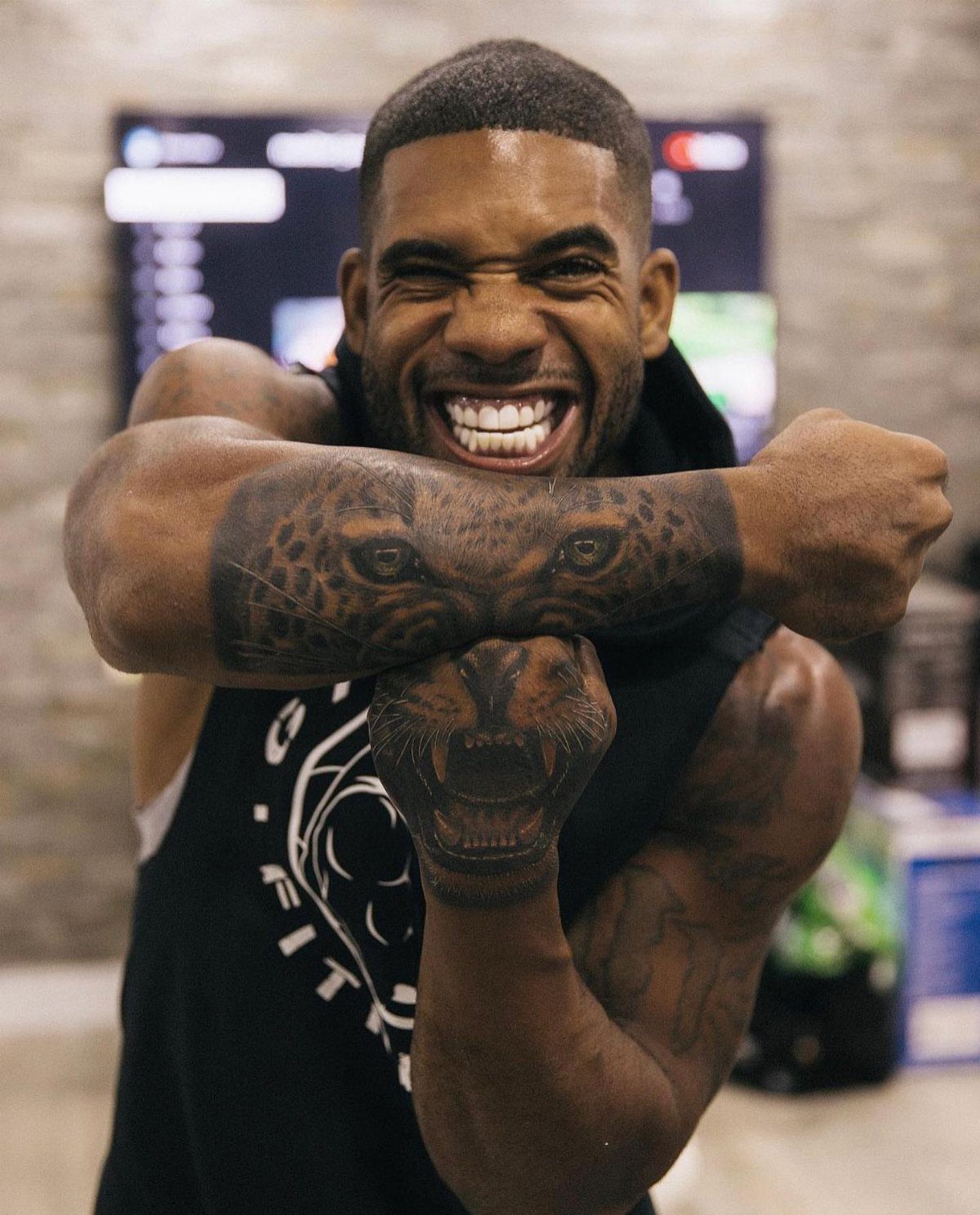 Man with a realistic leopard portrait tattoo on his forearm and elbow.