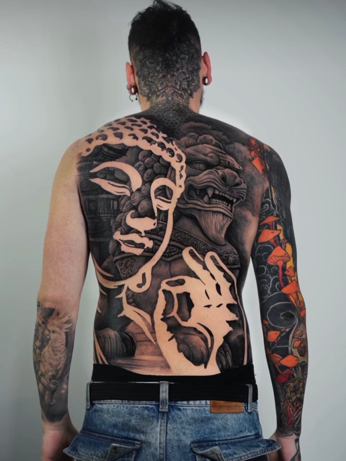 Large black and grey negative shading tattoo of Buddha on a man's back