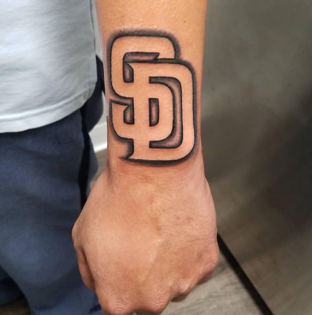 SD logo tattoo on a wrist using negative shading and black ink