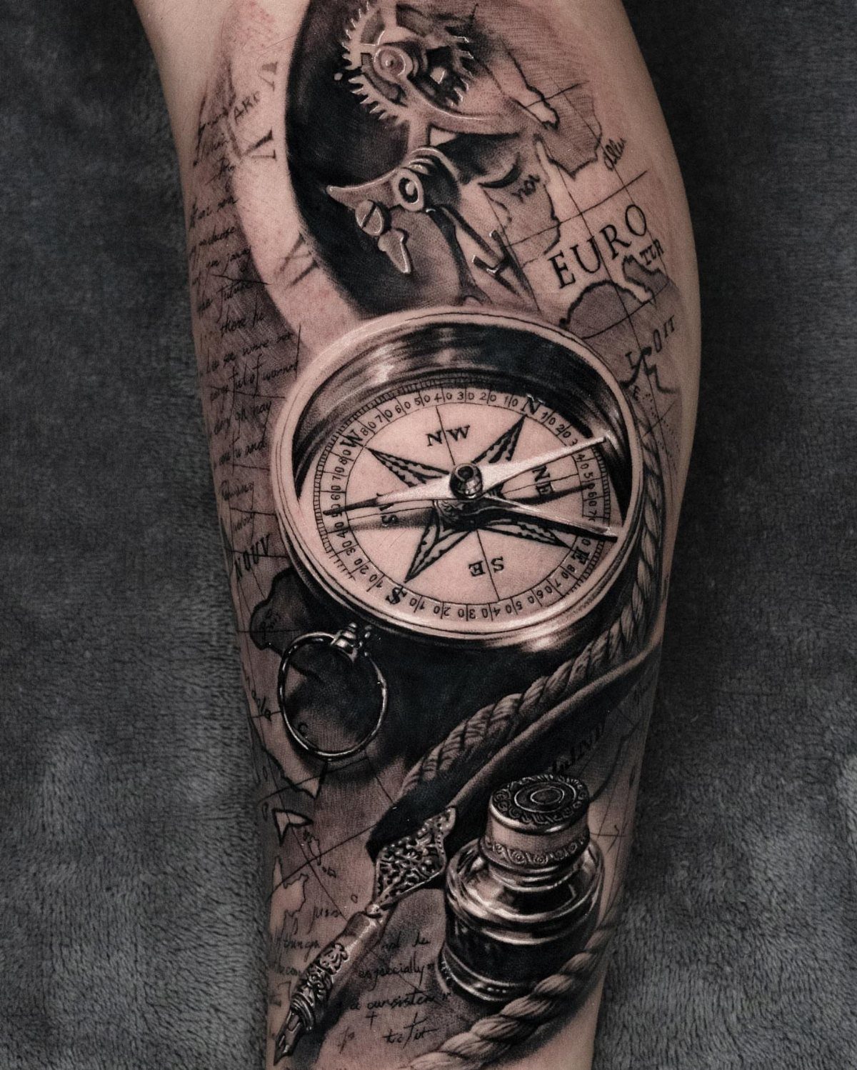 3D compass tattoo with inkwell and map on a person's arm
