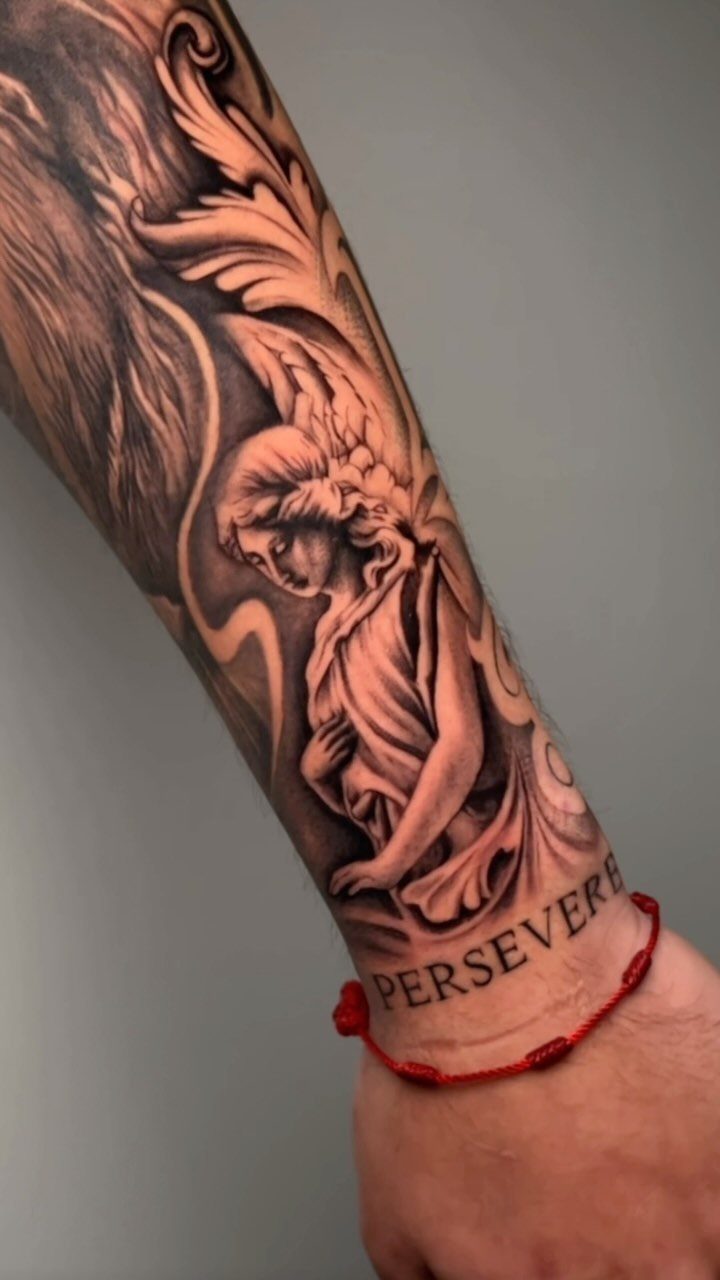 Angel tattoo on a forearm with ornate shading and the word perseverance.
