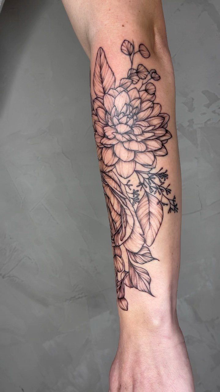 Linework rose tattoo with floral accents on a person's lower leg.