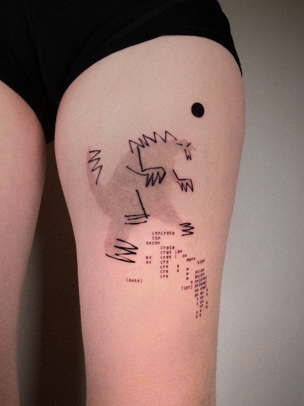 Black ink sketches of a creature and text on a person's thigh