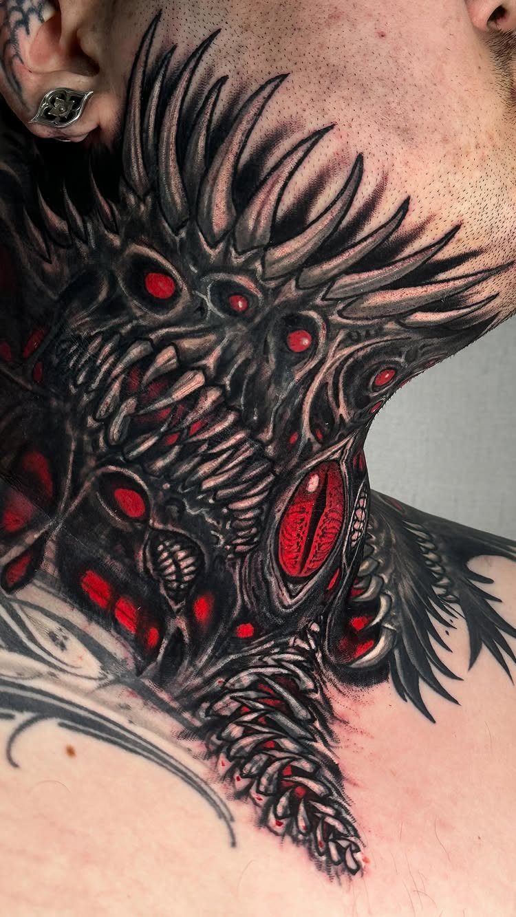 Biomechanical neck tattoo with black spikes and red accents on a person's skin