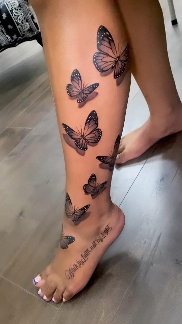 Black ink butterfly tattoos on a person's dark skin leg and foot.