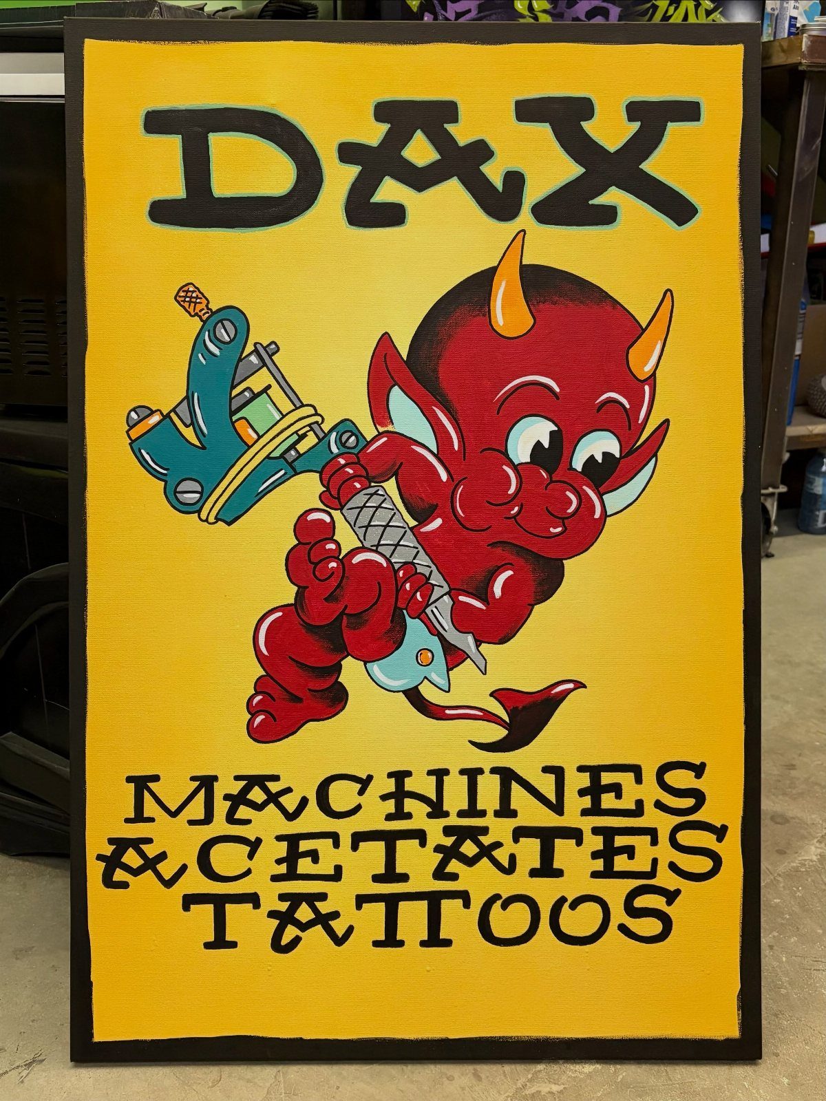 Red cartoon devil holding a blue tattoo machine on a yellow background.