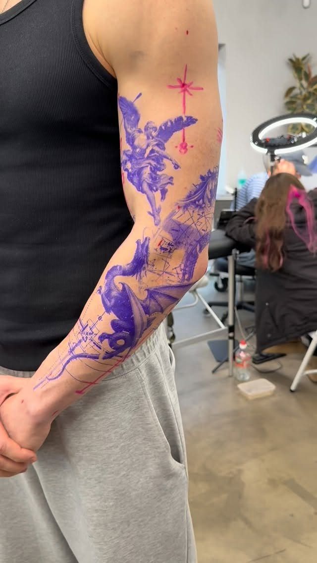 Tattoo stencils of an angel and dragon applied to a person's arm.