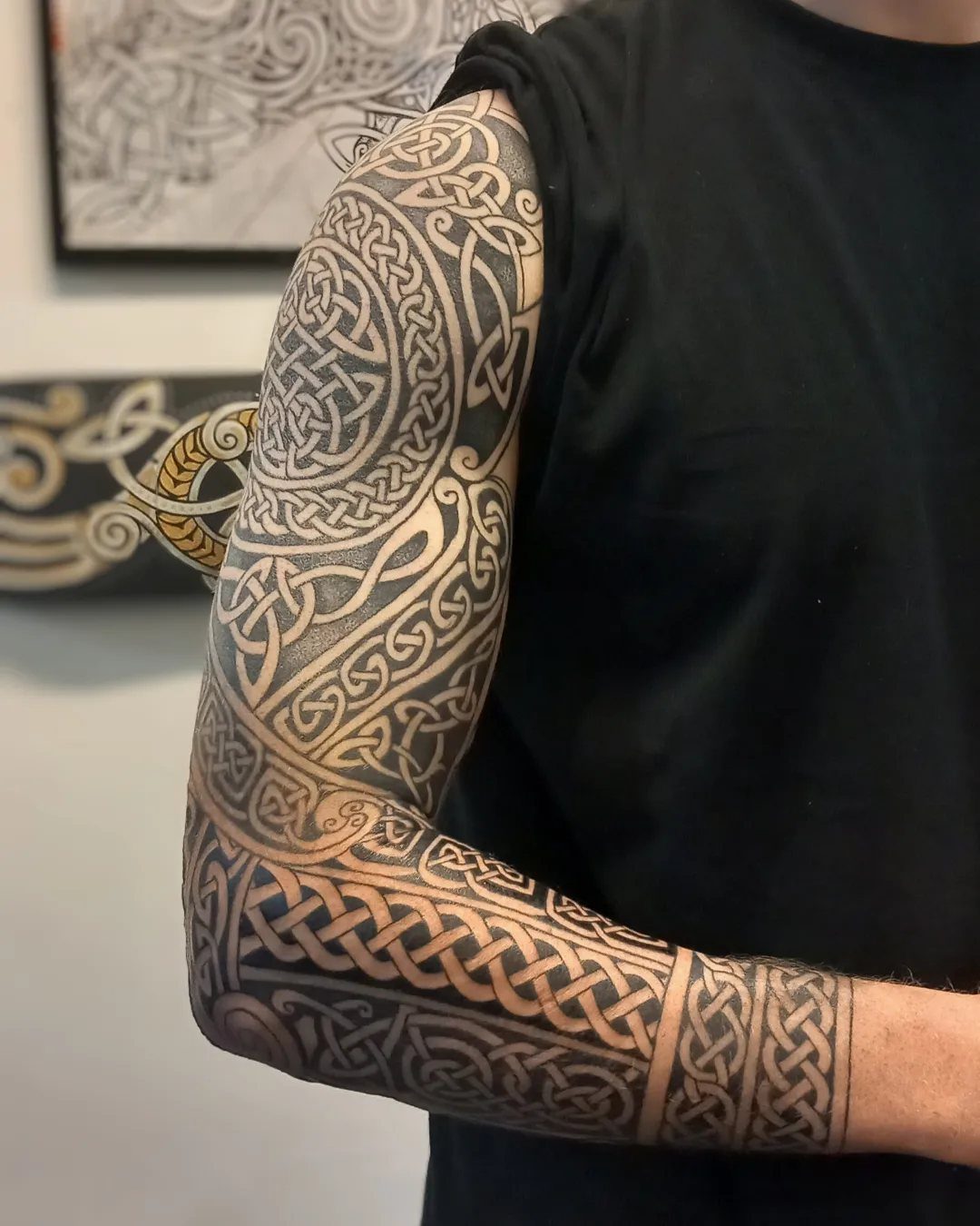 Celtic knotwork tattoo sleeve covering a person's entire arm from shoulder to wrist.
