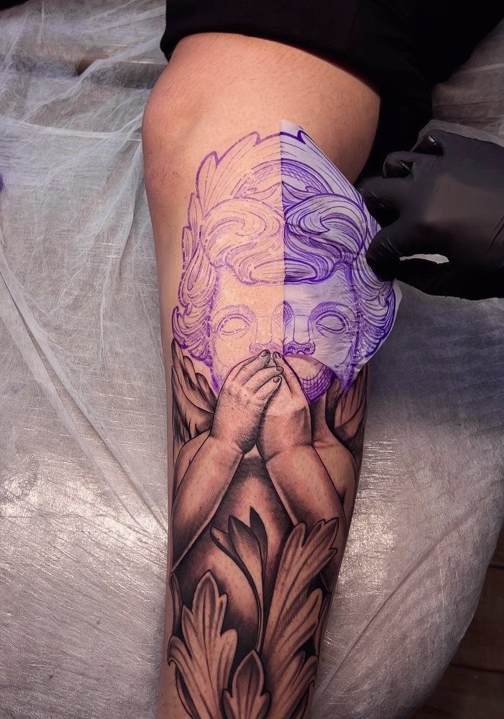 Tattoo stencil paper being peeled off a leg to reveal a purple outline design.