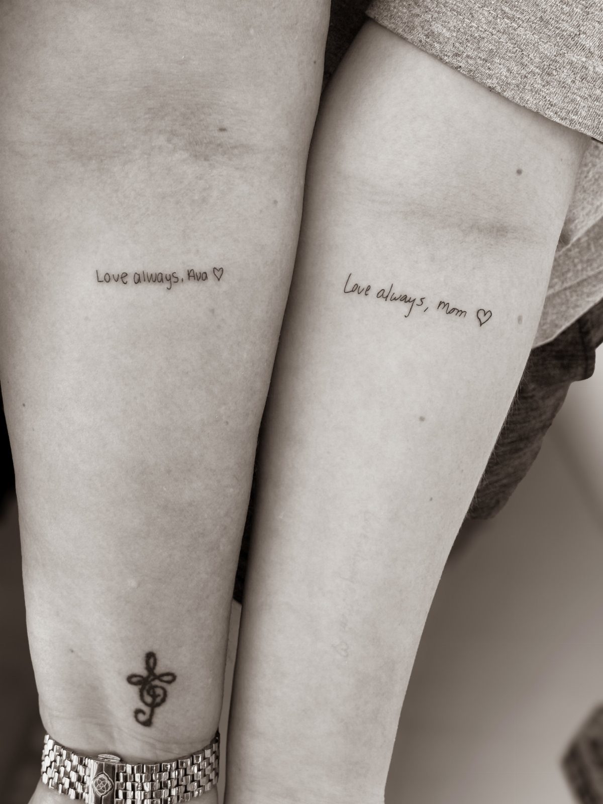 Two arms with matching tattoos reading Love always, Ava and Love always, Mom