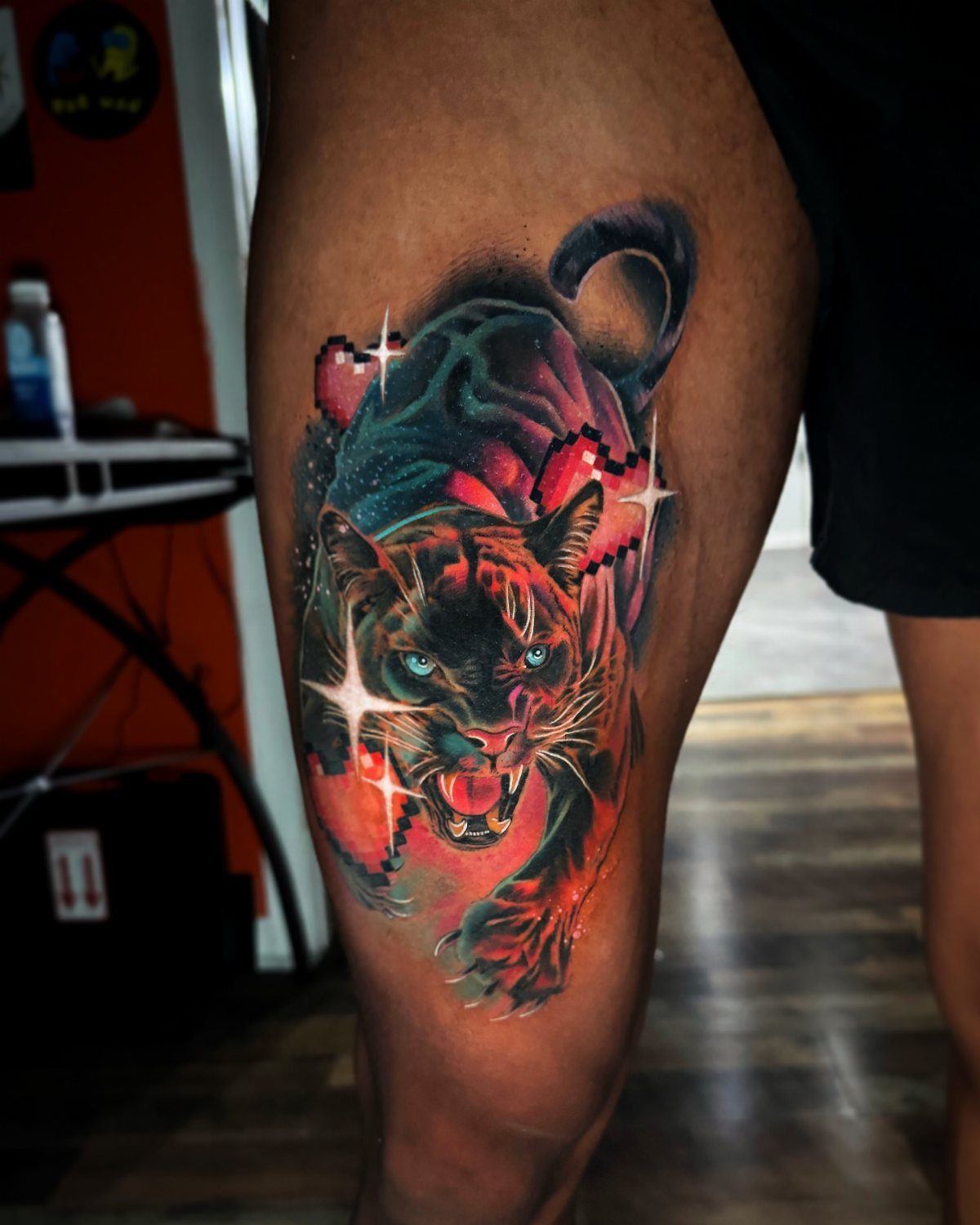 Panther tattoo with bold outlines and vibrant colors on dark skin