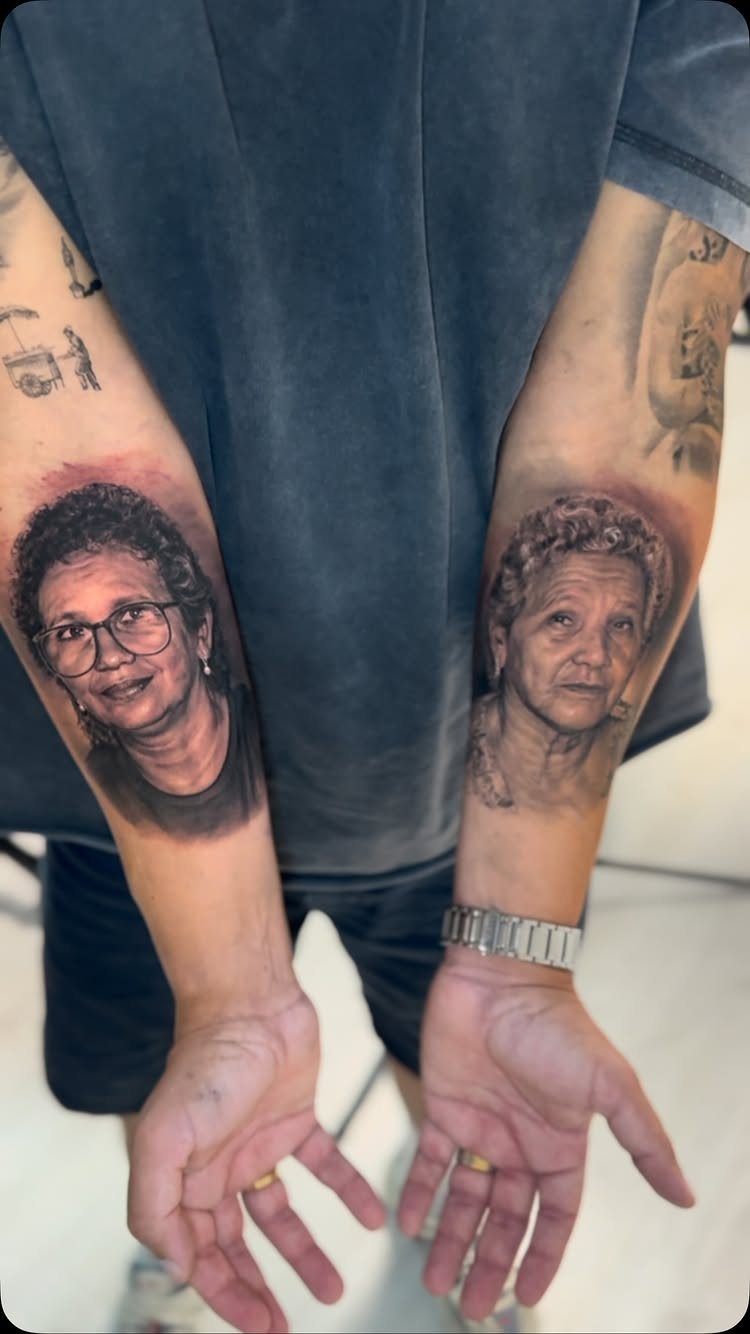 Realistic portrait tattoos of two women on a person's dark skin forearms.