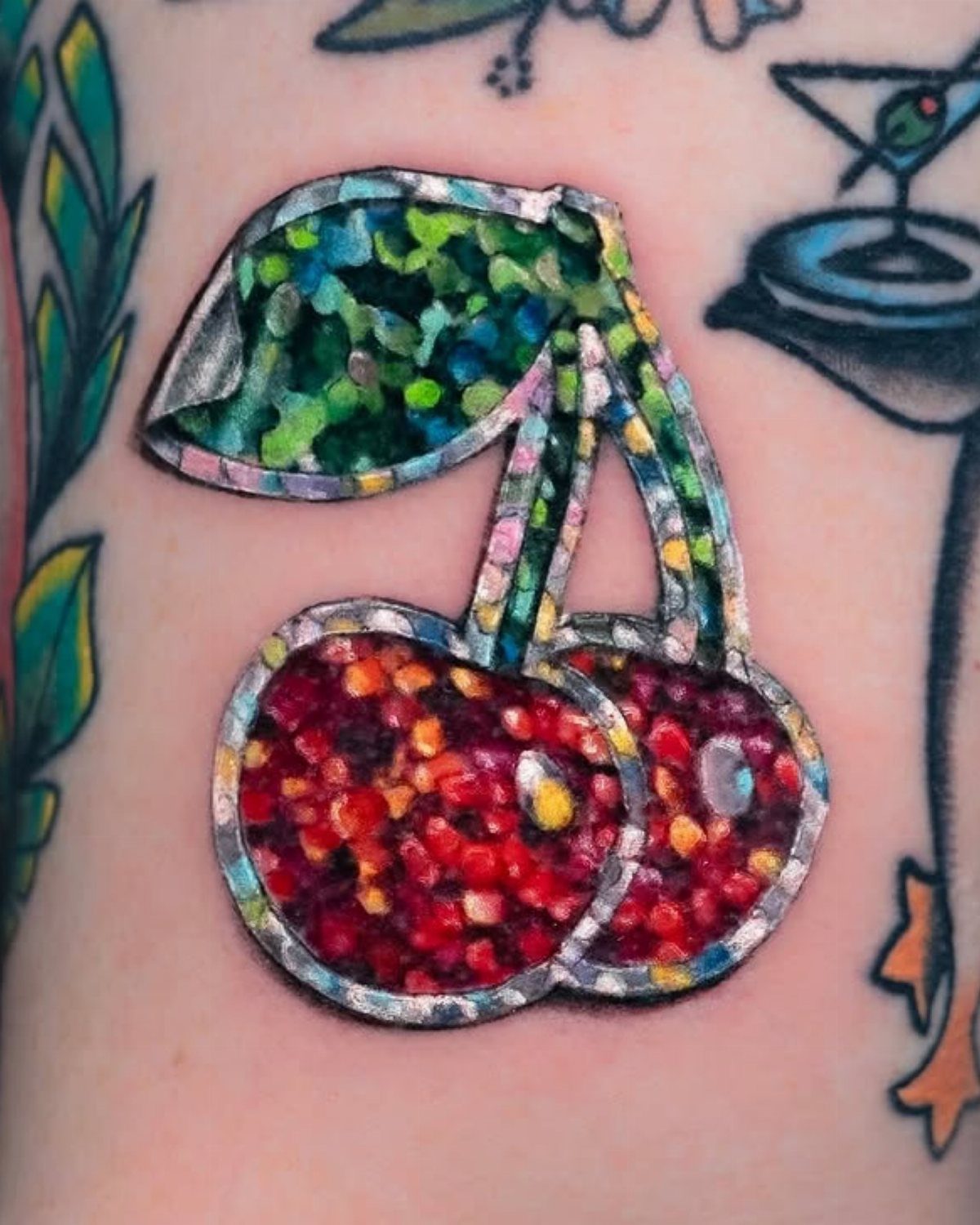 Cherry tattoo with glittery red and green fill and a white sticker border