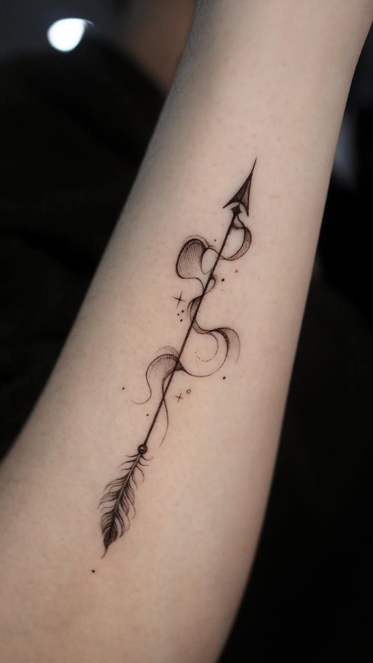 Black ink arrow tattoo with smoke swirls and stars on a forearm