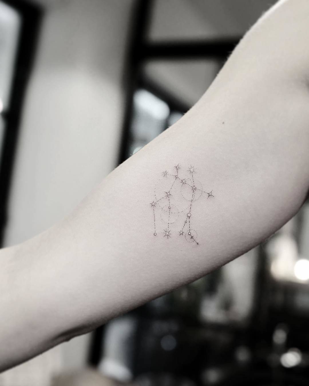 Constellation tattoo on a person's forearm with small stars and connecting lines.