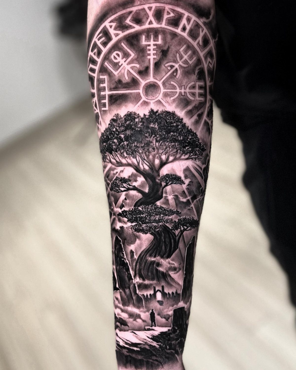 Vegvisir compass and rune tattoo above a large detailed tree on an arm