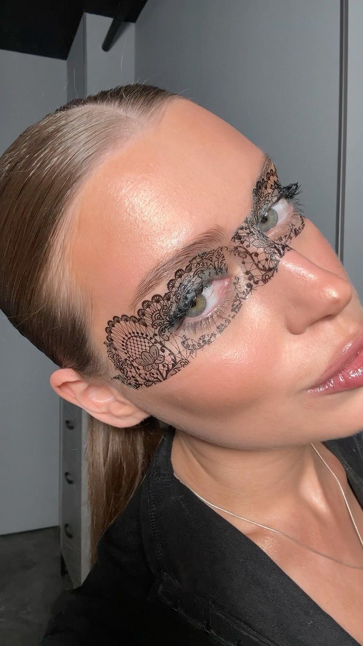 Woman with black lace temporary tattoo makeup across her eyes and nose