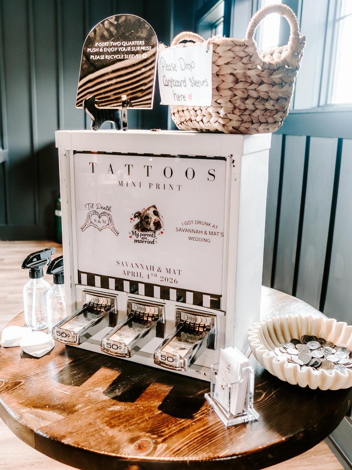 White temporary tattoo vending machine with coin slots on a wooden table.
