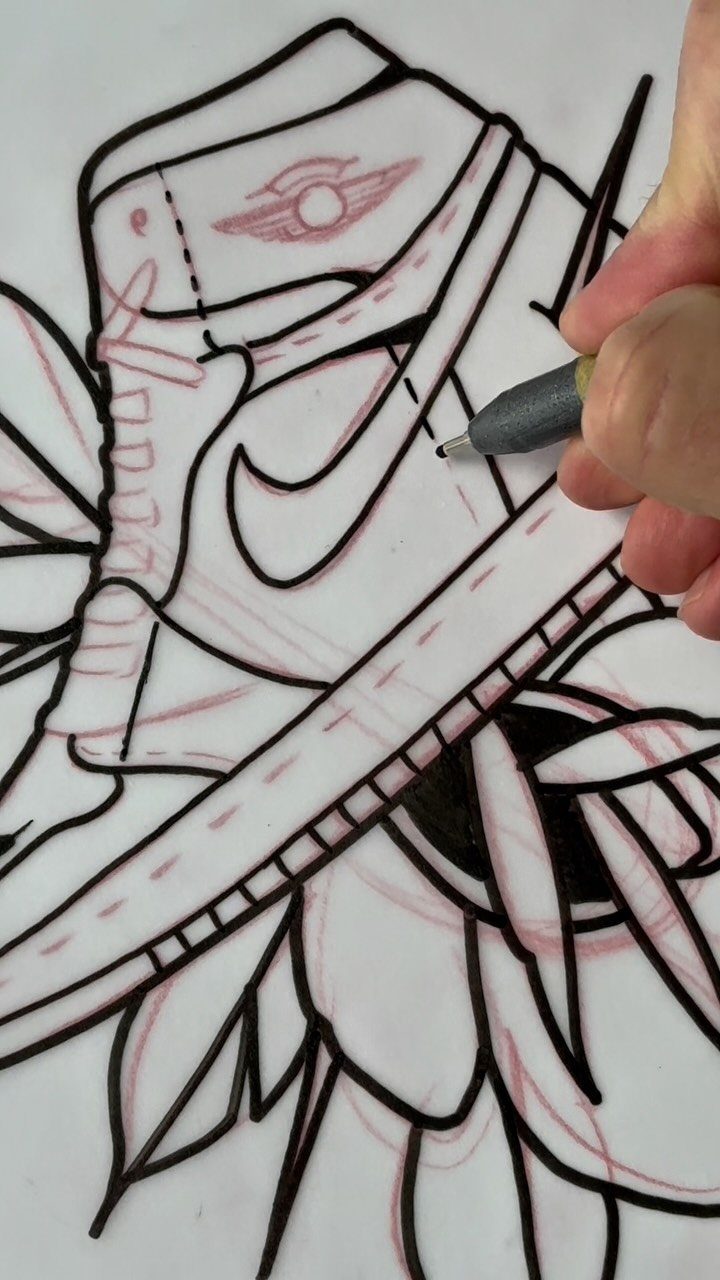 Hand tracing a sneaker tattoo design with a pencil on white paper