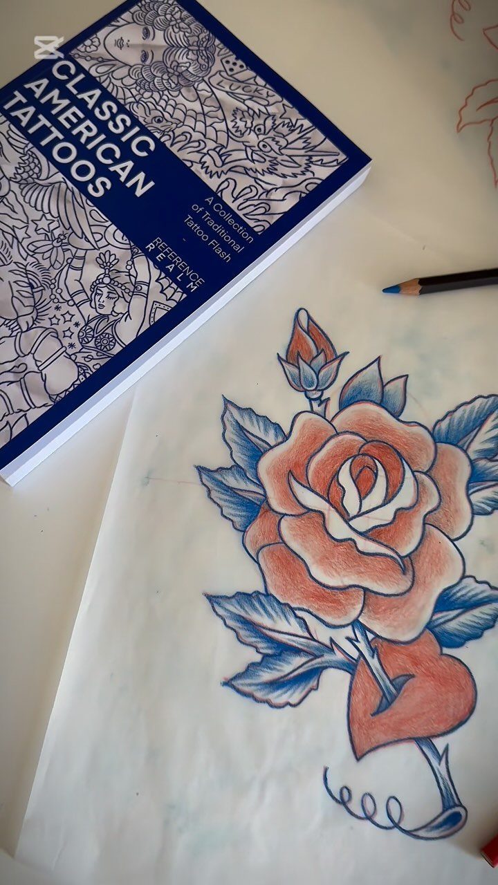Traditional tattoo design of a red rose and heart on white paper.