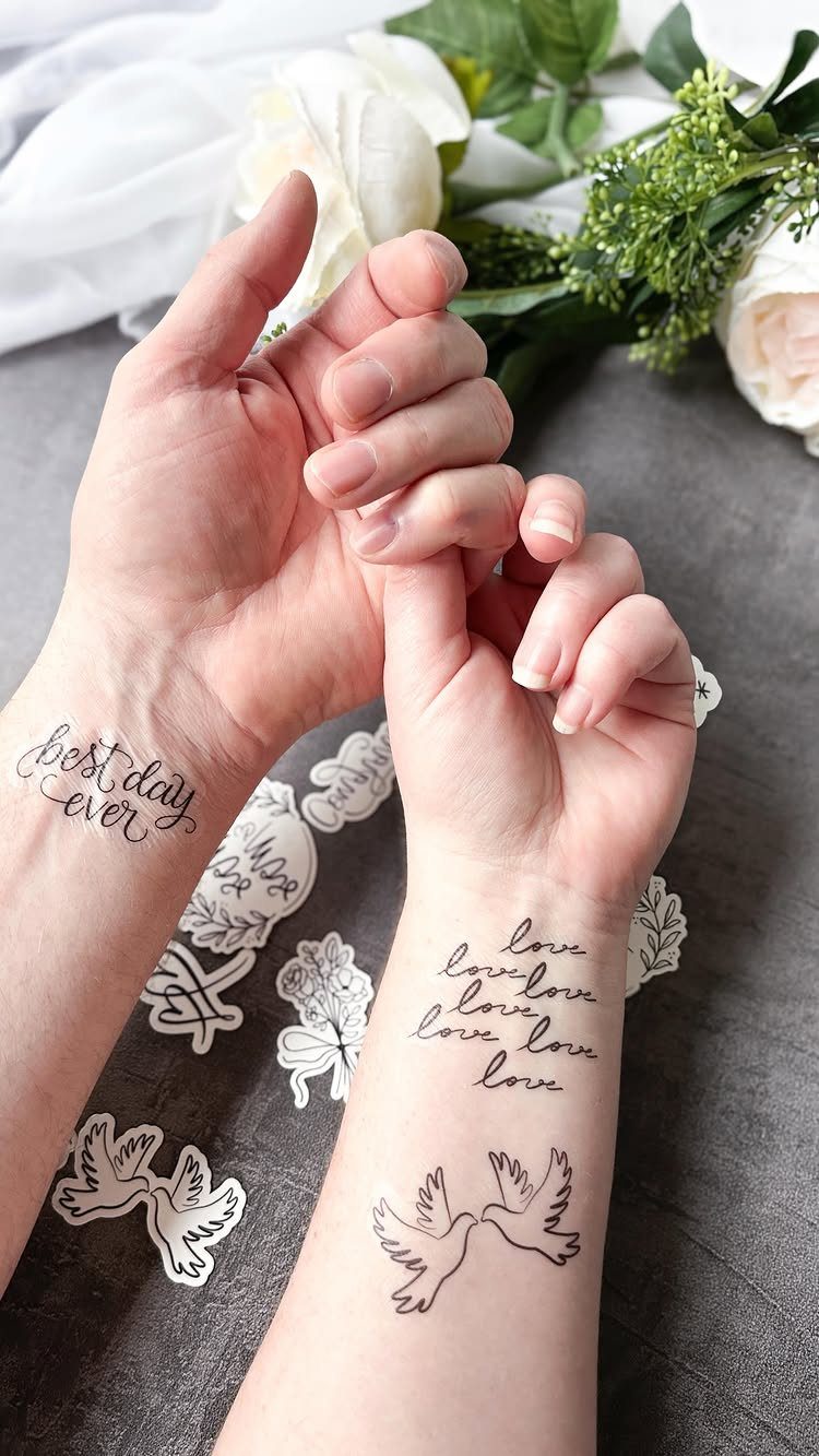 Temporary tattoos on wrists and forearms featuring love quotes and white doves.